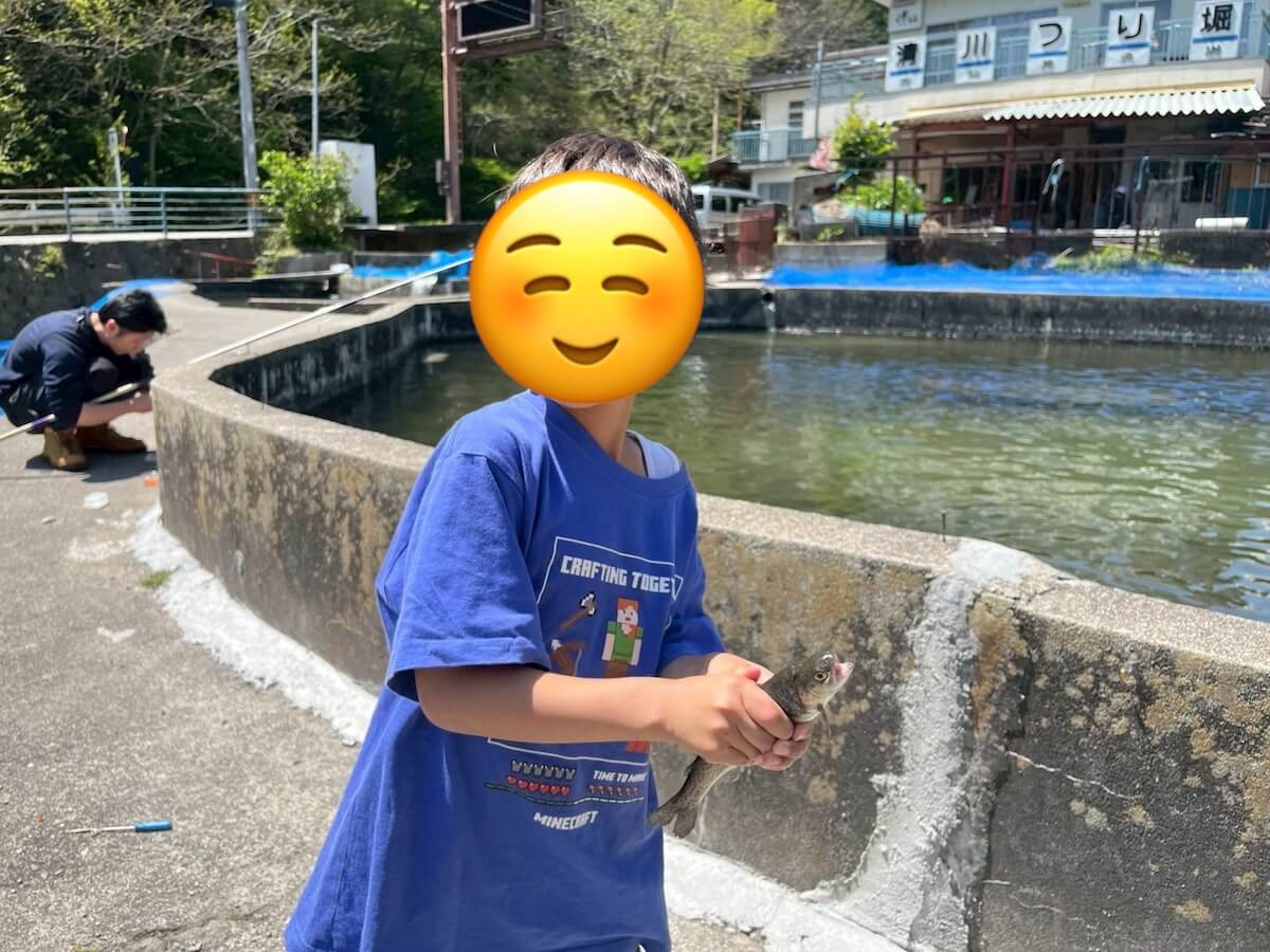 釣り堀の魚をガッチリ掴む子ども