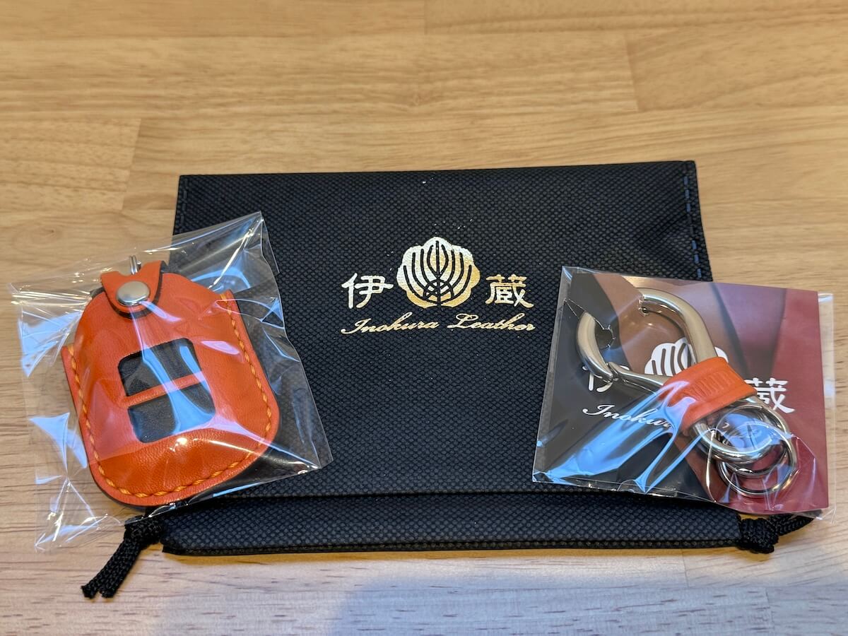 伊の蔵レザー キーウェアジャケット（WR-V用）と付属フックのパッケージ